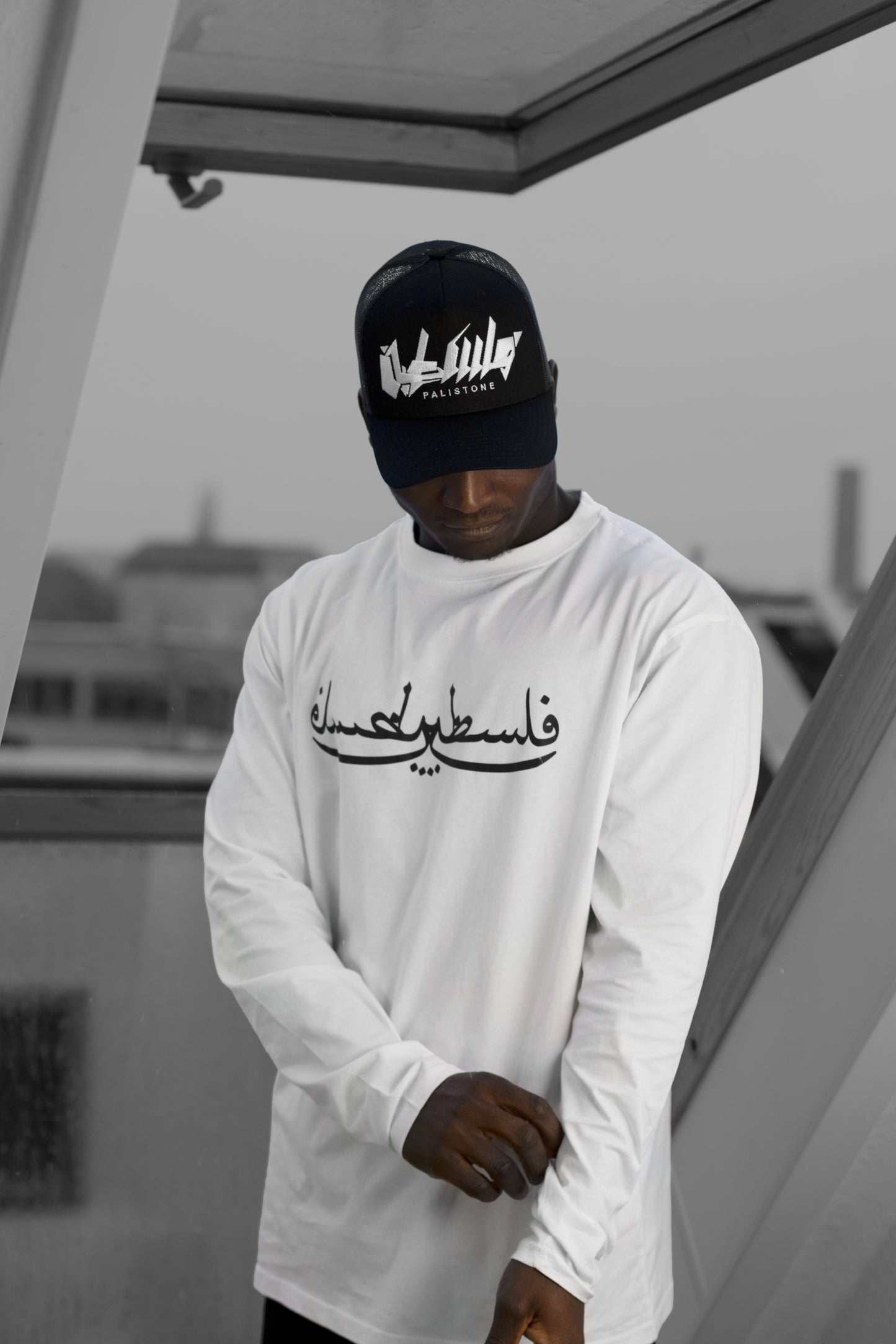 Embroidered Palestinian cap with ‘Palestine’ text in Arabic, black and white kufiya design.
