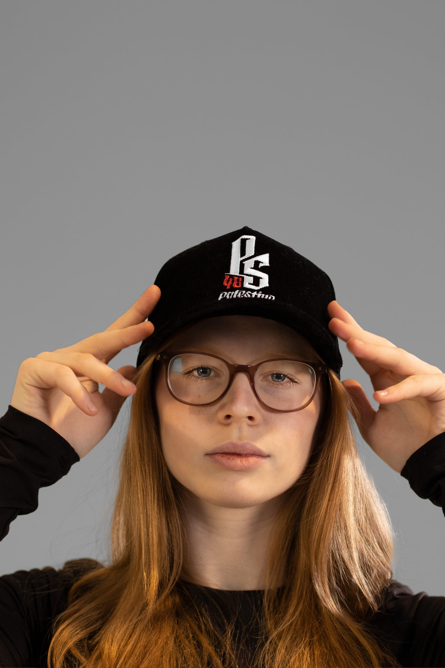 Embroidered Palestinian cap with ‘Palestine’ text in Arabic, black and white kufiya design.