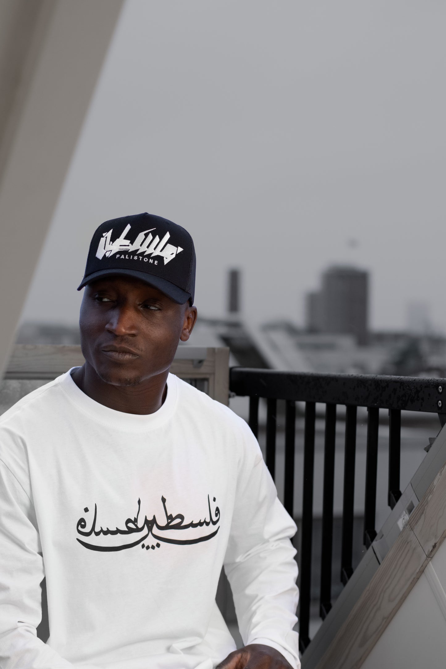 Embroidered Palestinian cap with ‘Palestine’ text in Arabic, black and white kufiya design.