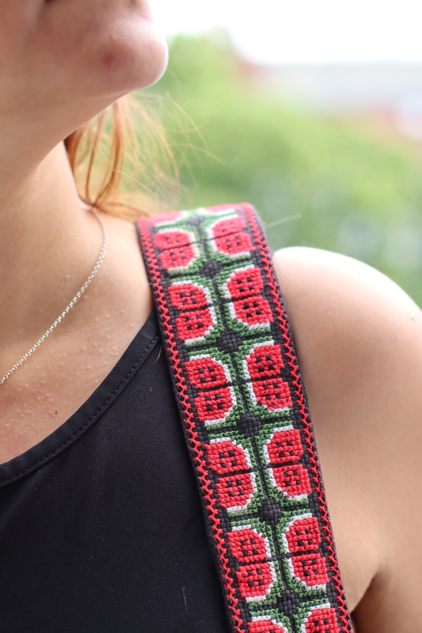 A girl wearing a Handmade leather belt with traditional embroidery watermelon from Hebron, Palestine, PaliStone brand.