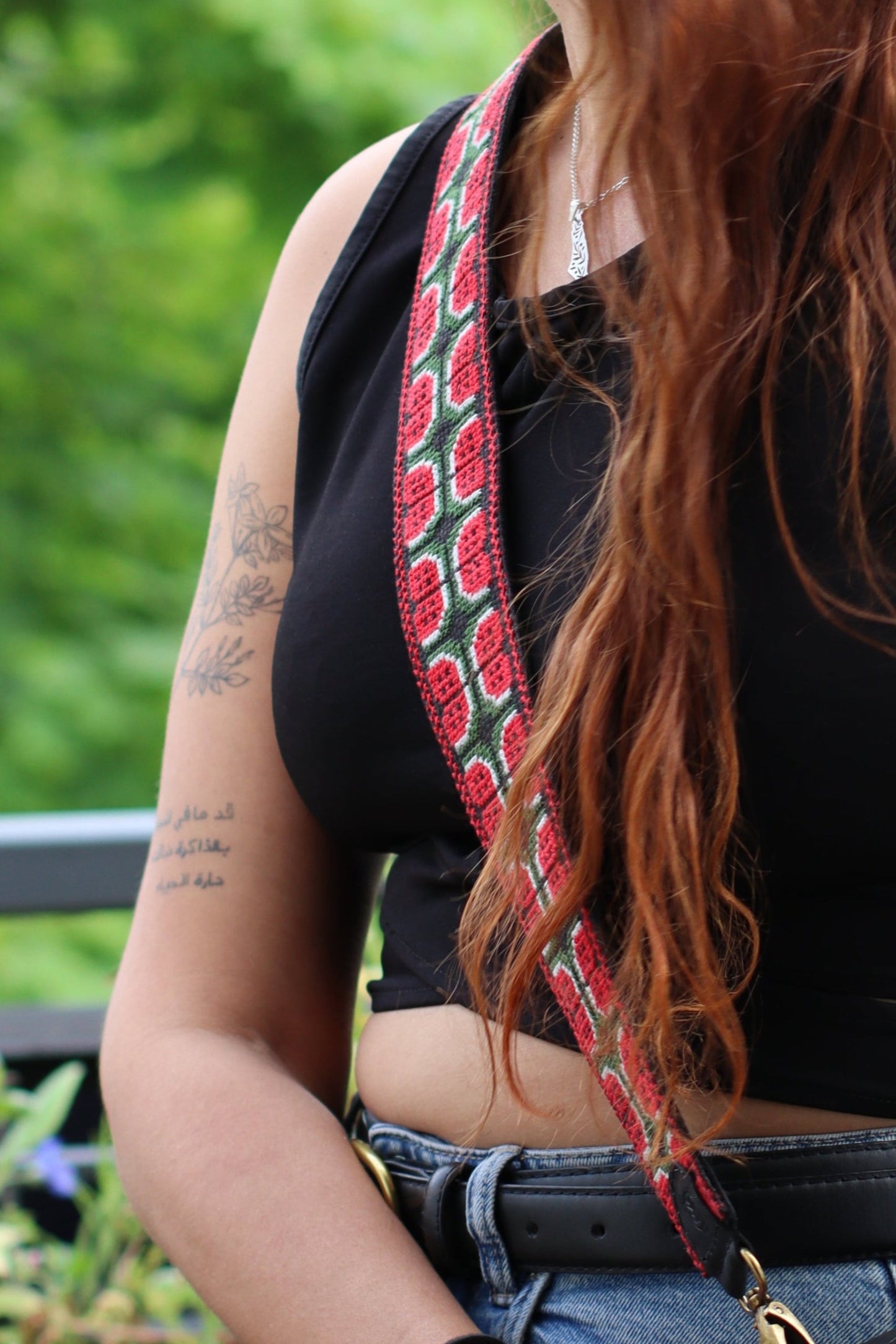A girl wearing a Handmade leather belt with traditional embroidery watermelon from Hebron, Palestine, PaliStone brand.