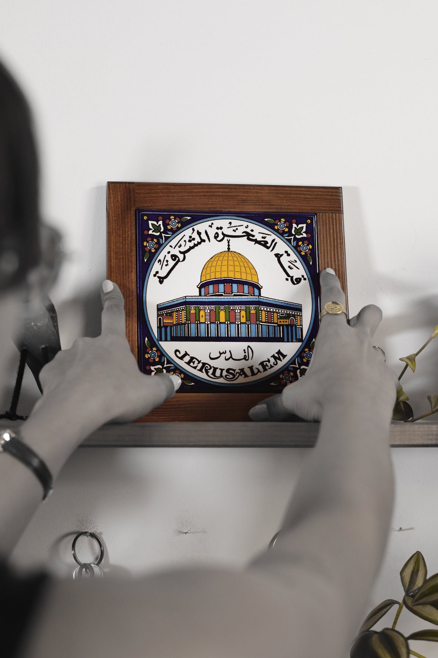 “Handcrafted wooden frame from Hebron, Palestine, featuring intricate ceramic decorations and vibrant, bold colors, showcasing traditional Palestinian craftsmanship.” palistone brand