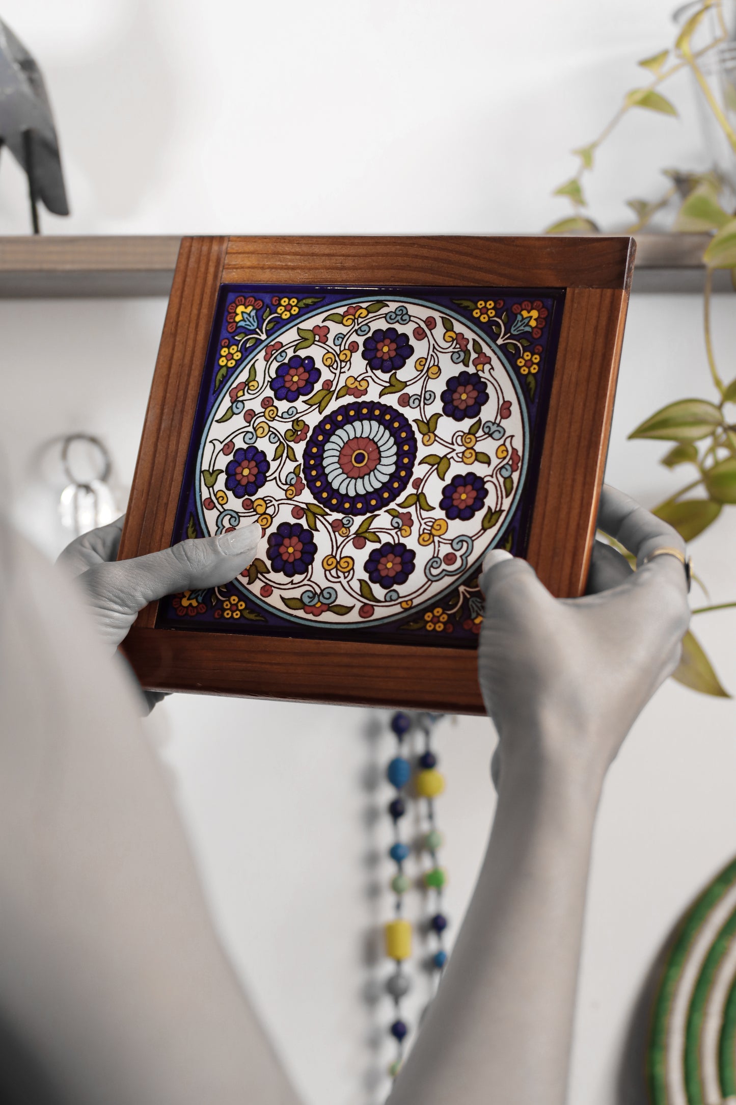 “Handcrafted wooden frame from Hebron, Palestine, featuring intricate ceramic decorations and vibrant, bold colors, showcasing traditional Palestinian craftsmanship.” palistone brand