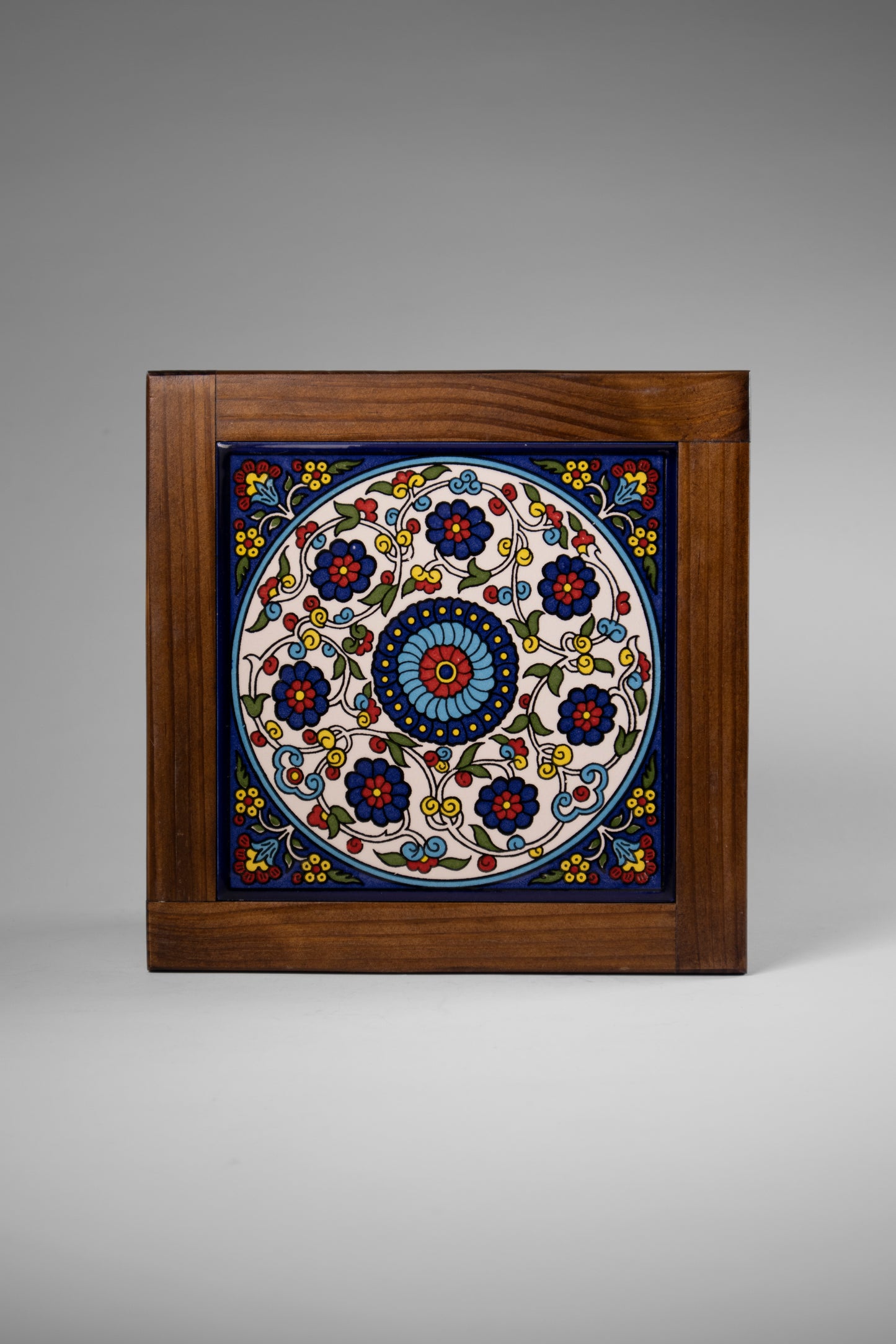 “Handcrafted wooden frame from Hebron, Palestine, featuring intricate ceramic decorations and vibrant, bold colors, showcasing traditional Palestinian craftsmanship.” palistone brand