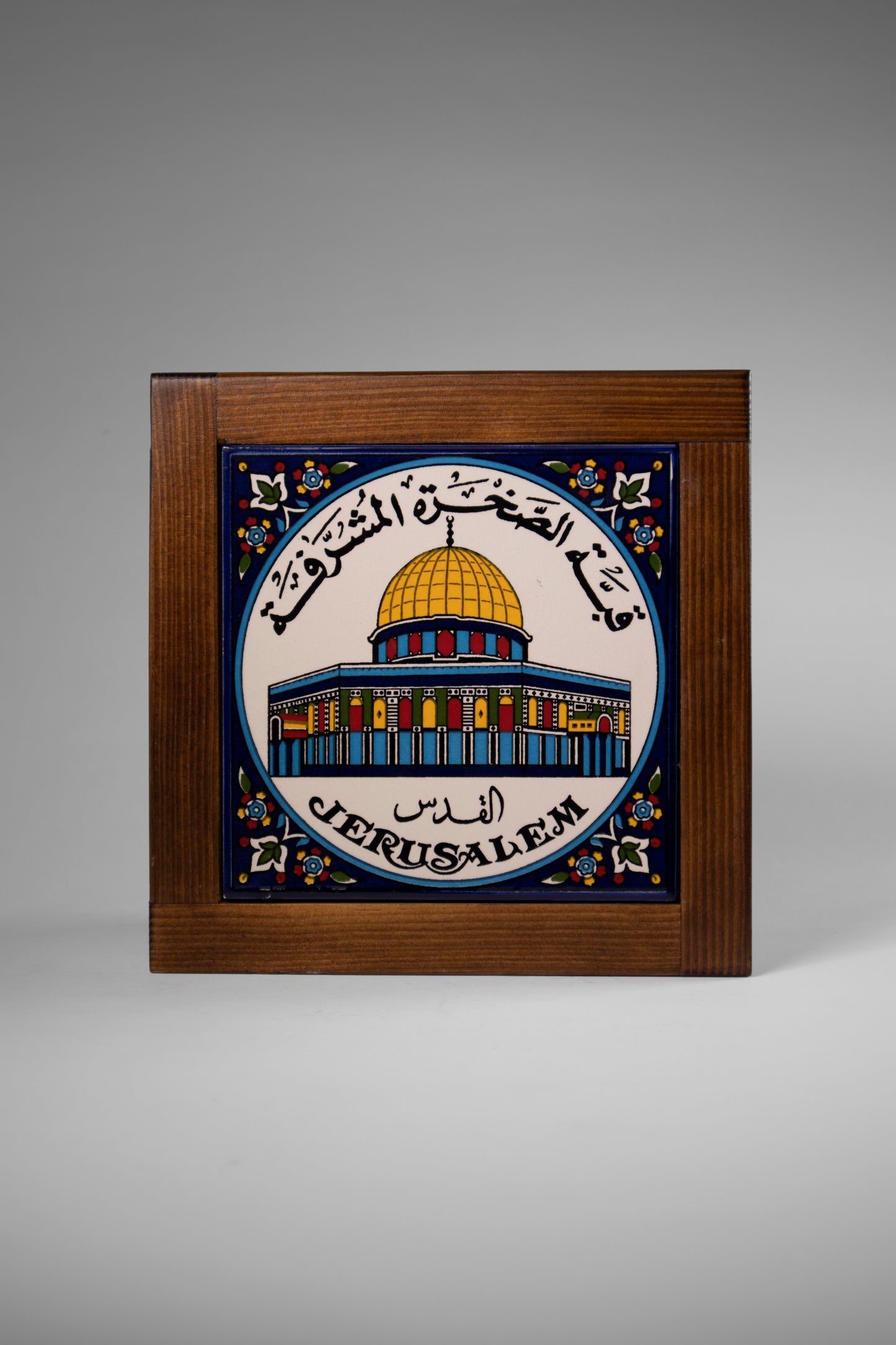 “Handcrafted wooden frame from Hebron, Palestine, featuring intricate ceramic decorations and vibrant, bold colors, showcasing traditional Palestinian craftsmanship.” palistone brand