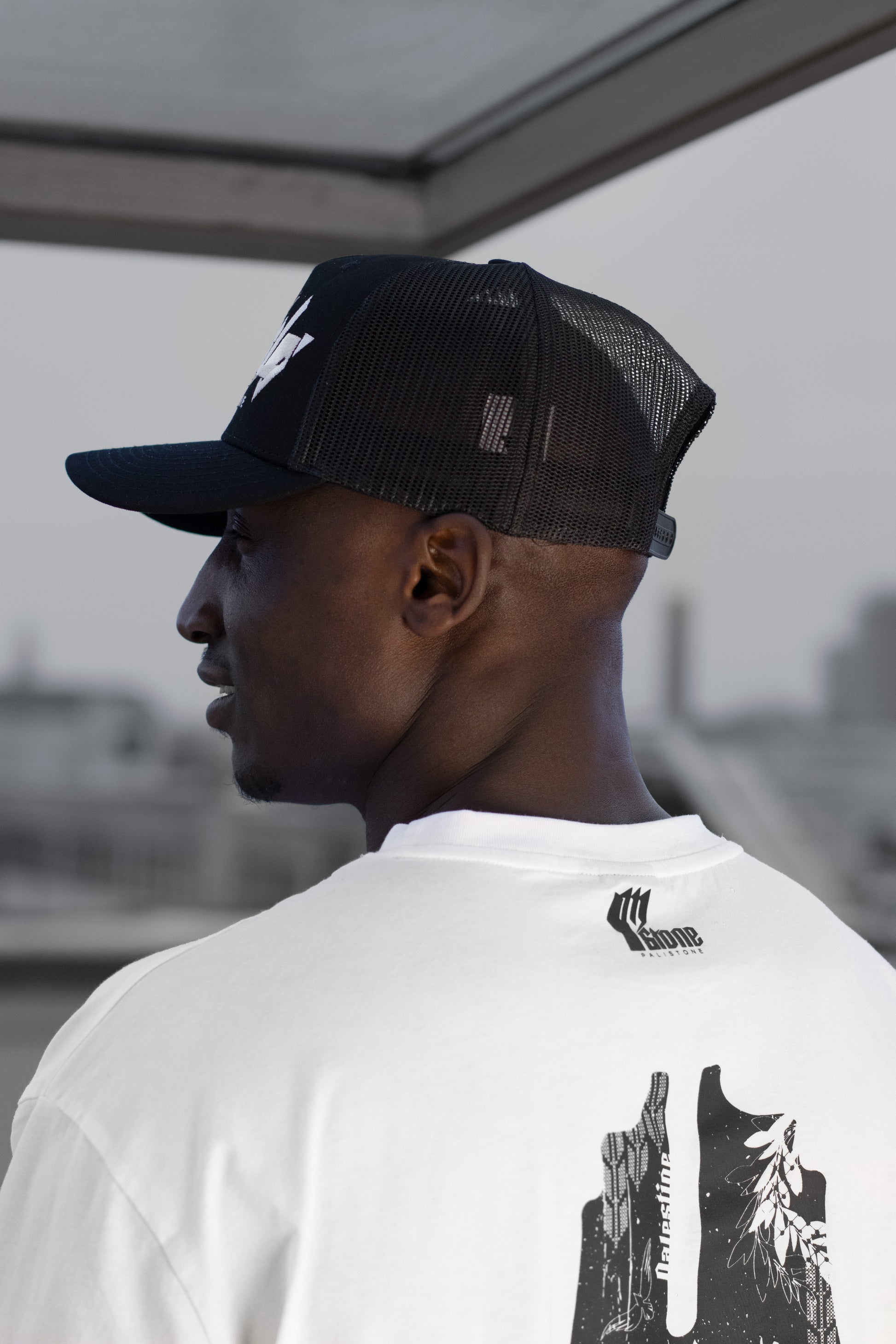 Embroidered Palestinian cap with ‘Palestine’ text in Arabic, black and white kufiya design.