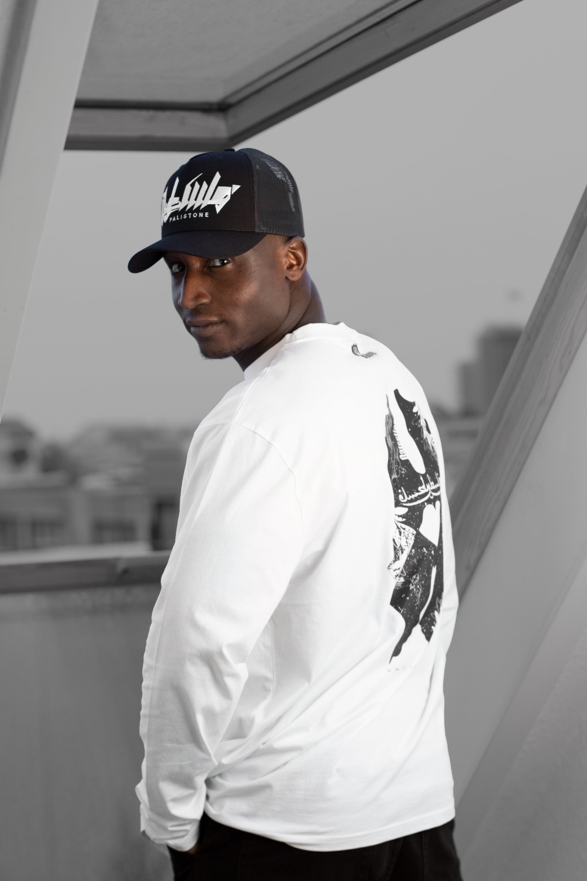 Embroidered Palestinian cap with ‘Palestine’ text in Arabic, black and white kufiya design.