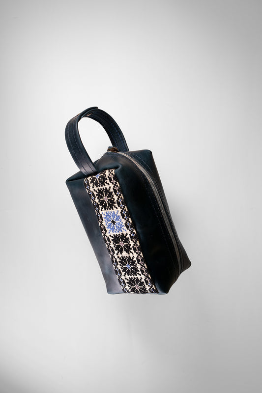 “Handmade leather clutch bag with traditional hand embroidery, crafted in Palestine.”