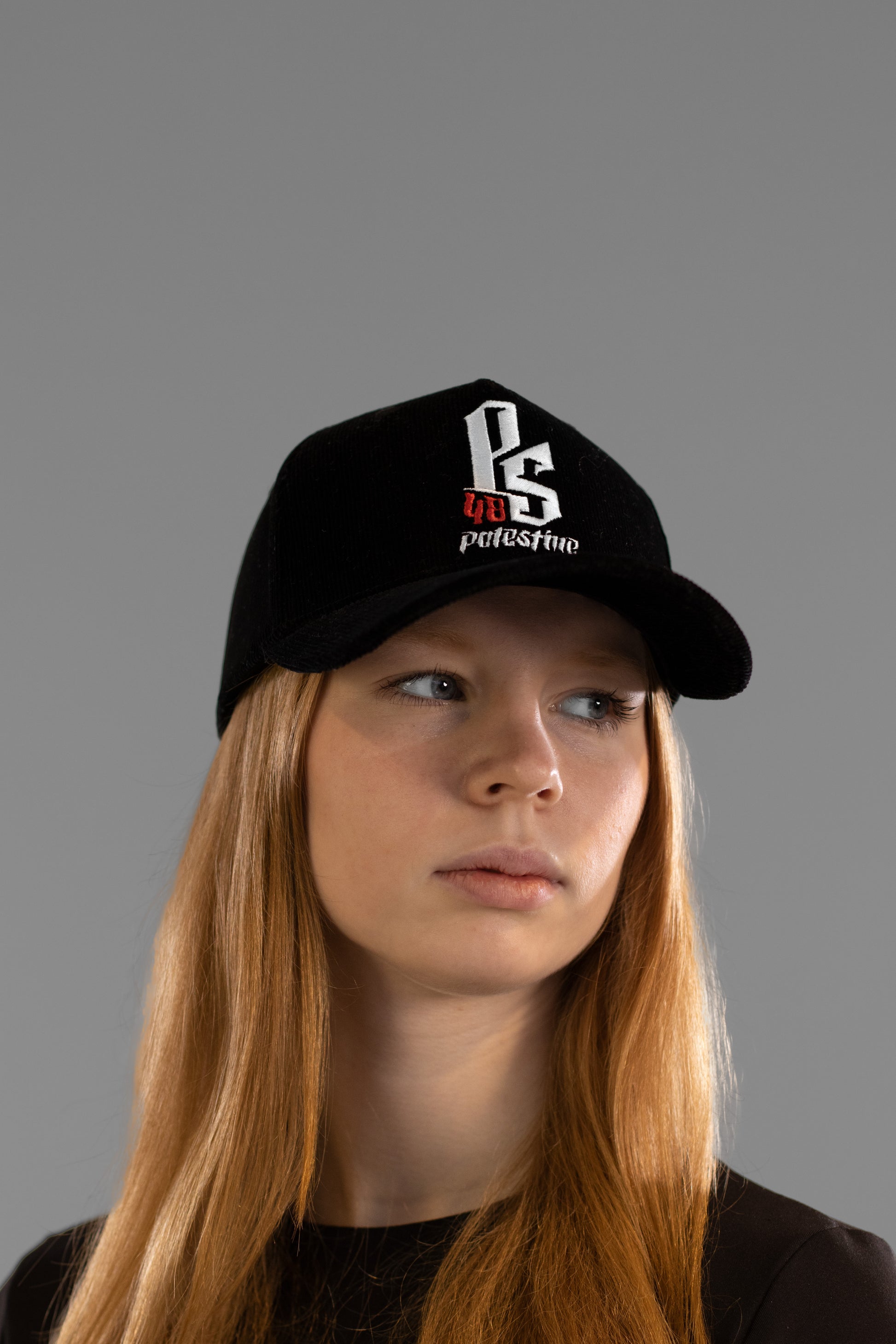 Embroidered Palestinian cap with ‘Palestine’ text in Arabic, black and white kufiya design.