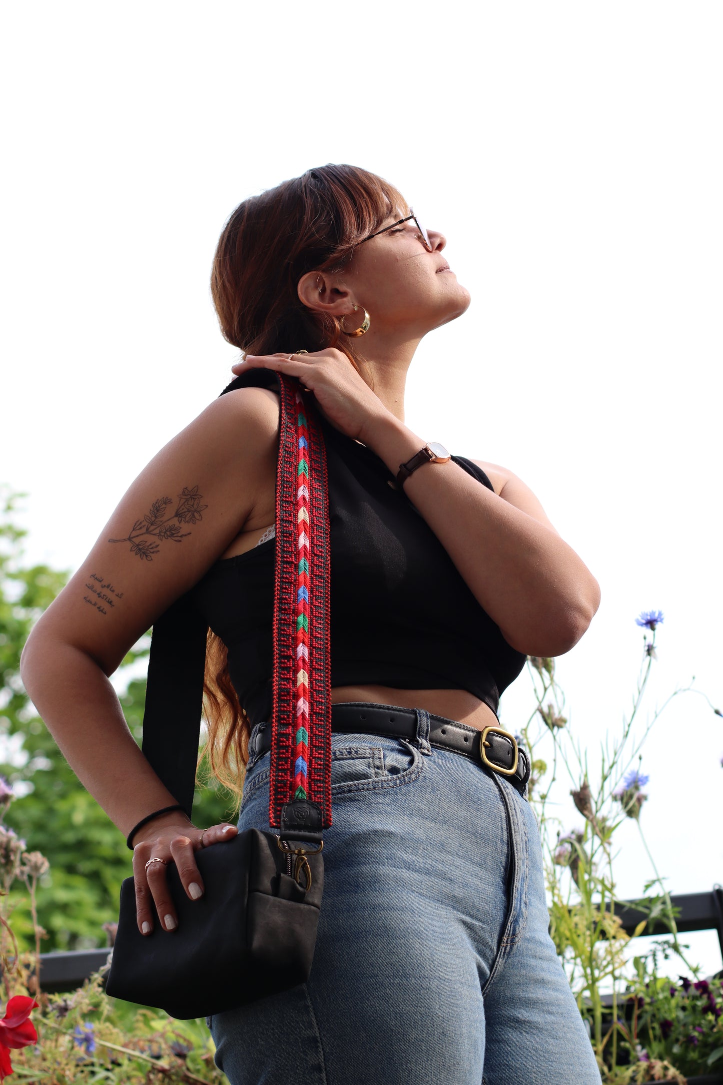 A girl wearing a Handmade leather belt with traditional embroidery from Hebron, Palestine, PaliStone brand.”
