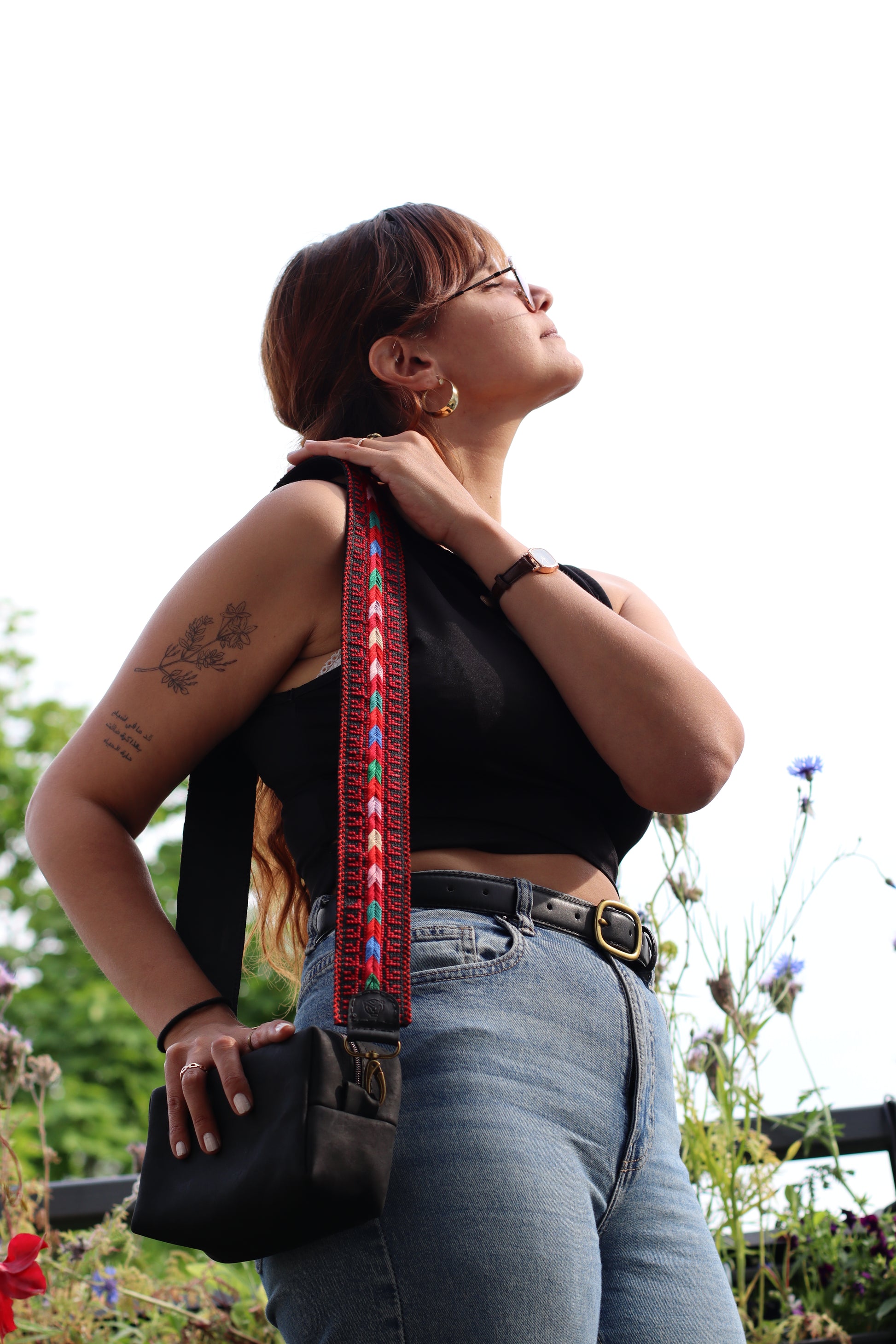 A girl wearing a Handmade leather belt with traditional embroidery from Hebron, Palestine, PaliStone brand.”