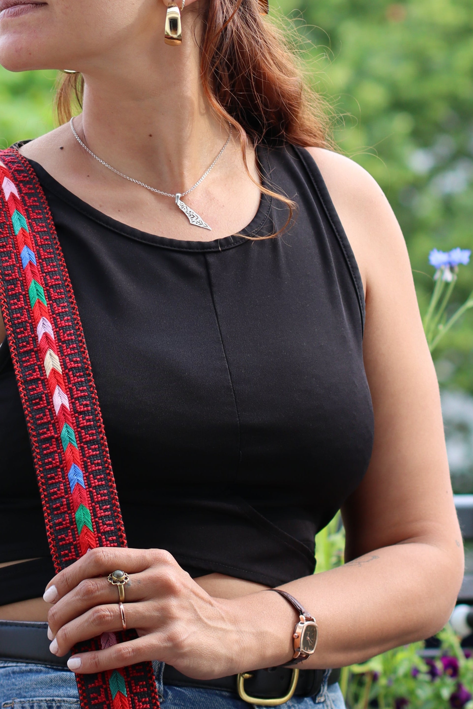 A girl wearing a Handmade leather belt with traditional embroidery from Hebron, Palestine, PaliStone brand.”