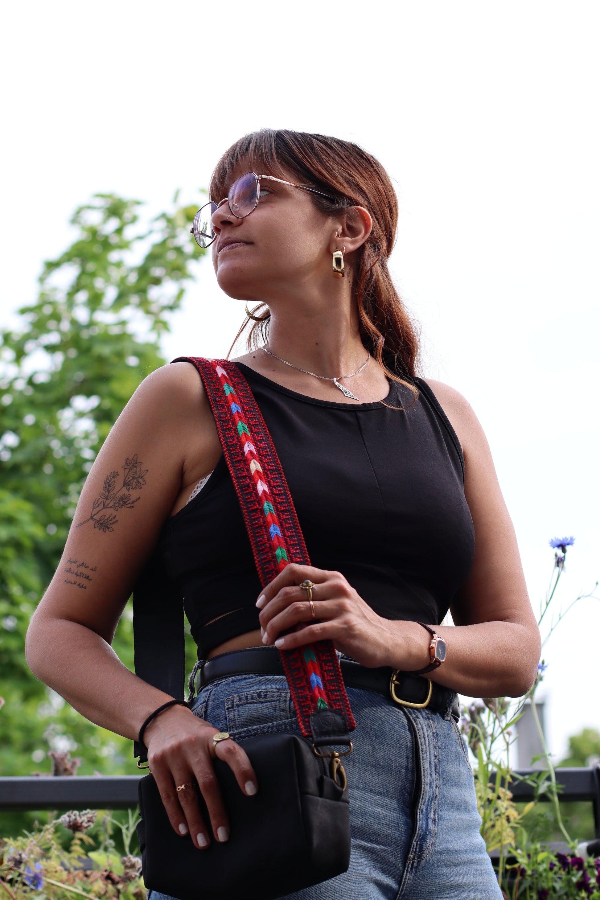 A girl wearing a Handmade leather belt with traditional embroidery from Hebron, Palestine, PaliStone brand.”