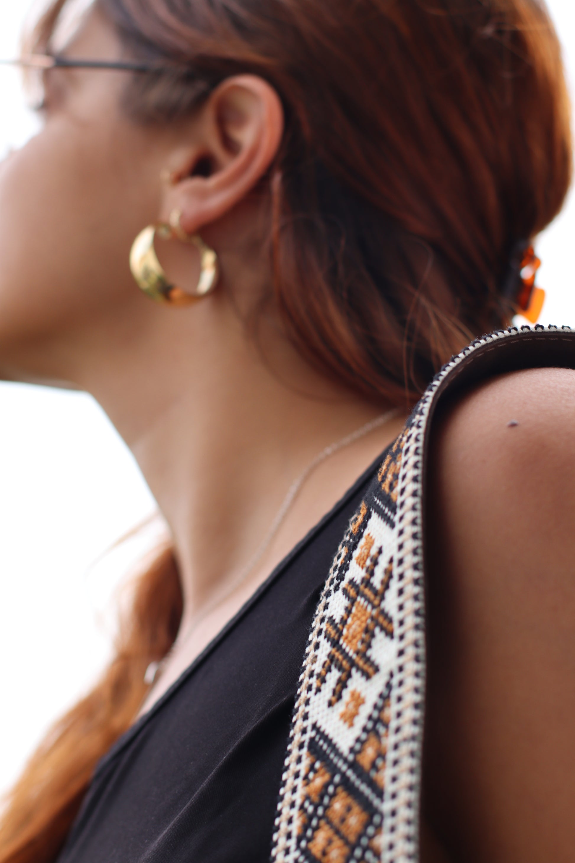 A Girl holding a Handmade leather belt with traditional embroidery from Hebron, Palestine, PaliStone brand.