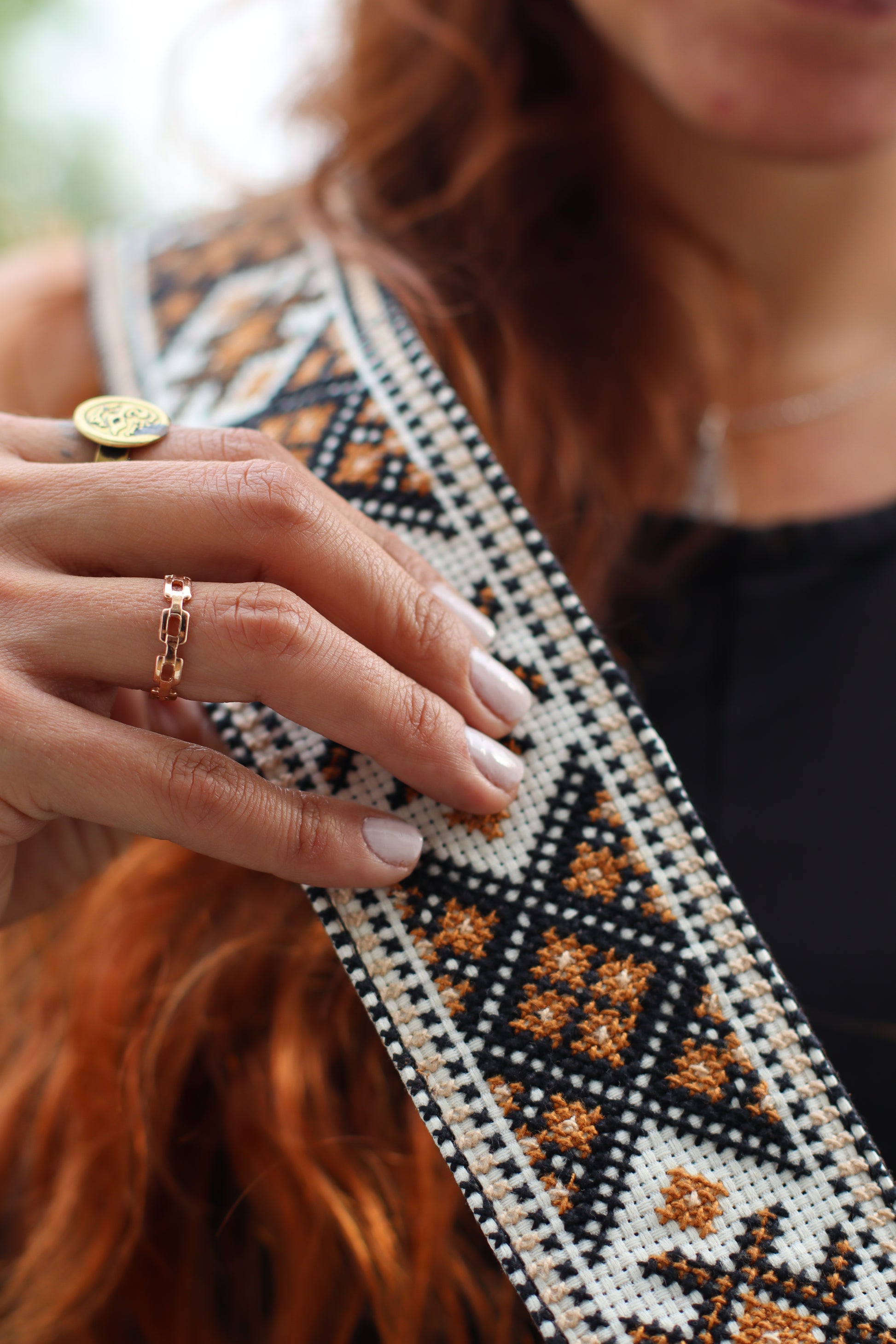 A Girl holding a Handmade leather belt with traditional embroidery from Hebron, Palestine, PaliStone brand.