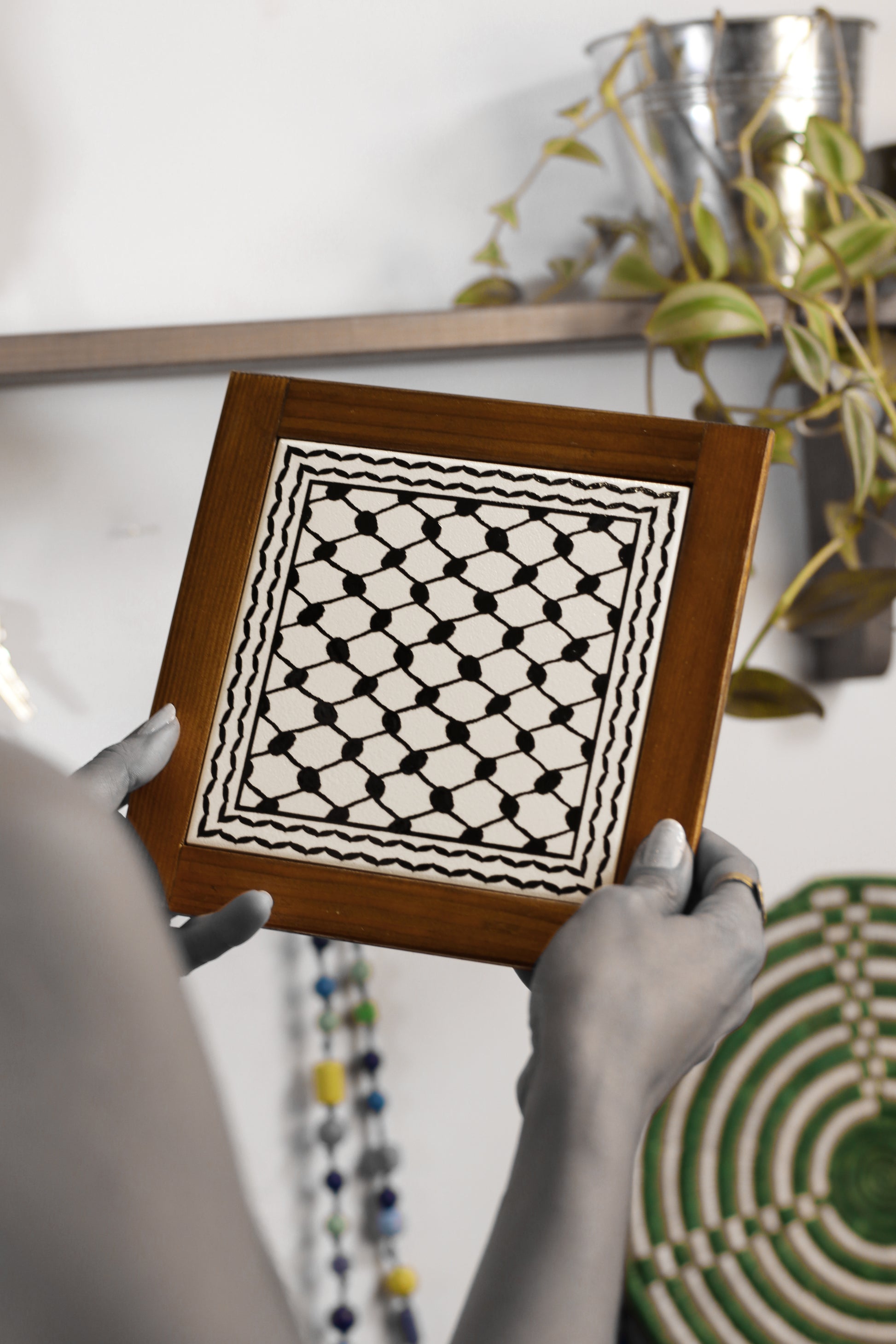 “Handcrafted wooden frame from Hebron, Palestine, featuring intricate ceramic decorations and vibrant, bold colors, showcasing traditional Palestinian craftsmanship.” palistone brand